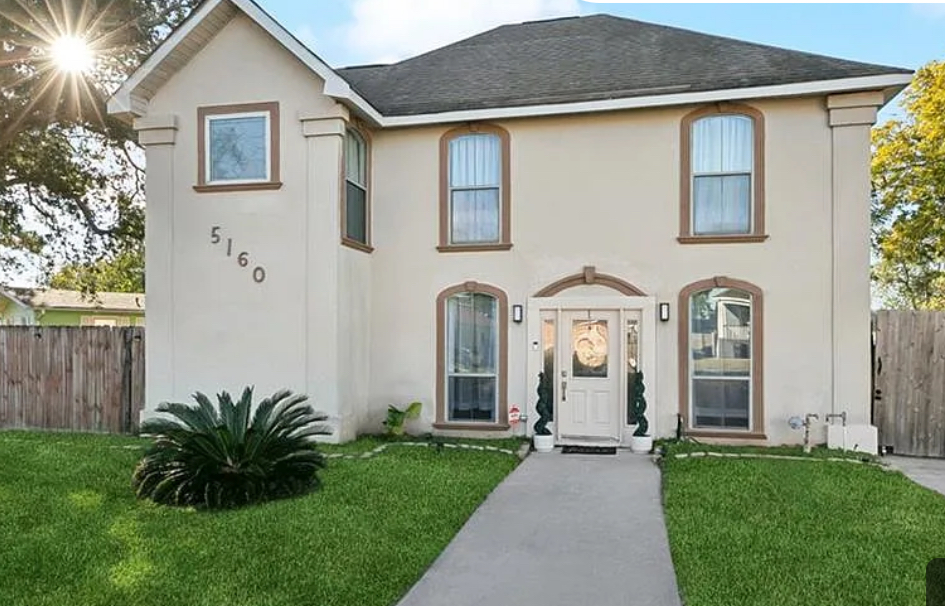 Two-story stucco home with arched windows in New Orleans